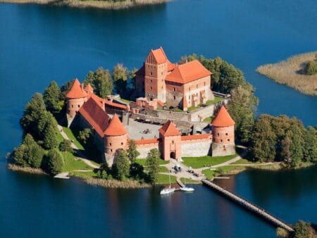 Schlossanlage auf einer Insel, von Wasser umgeben.